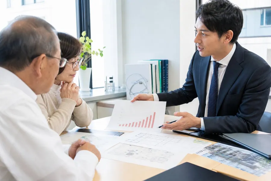 担当者がグラフを見せながら説明する様子